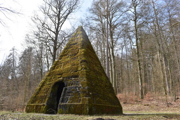Ancient stone pyramid with moss in the forest on the way to the World Cultural Heritage Herkules in Kassel, Wilhelmshöhe, Germany