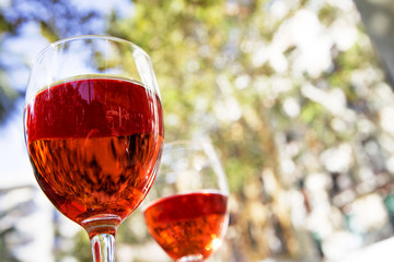 Obraz na płótnie Canvas two glasses of red wine on the table of a street cafe on a bright sunny day