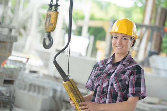 portrait of female worker holding winch controls