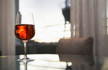 a glass of red wine on the table in the room