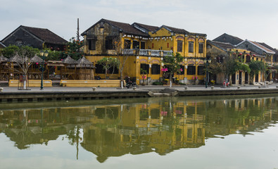 Fototapeta na wymiar old town of Hoi An golden buildings reflected in the river 