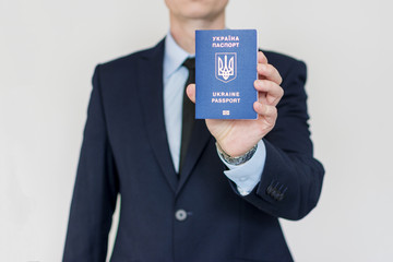 Suit Up Business Man holding Ukraine passport in right hand