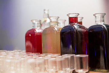 bottles with homemade tinctures and glasses on the table