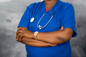 Female doctor's hands standing with hands crossed on chest.