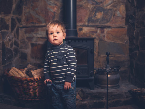 Toddler standing by log burner
