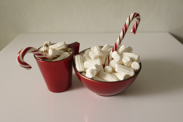 Christmas background, greeting card with a Cup of coffee or chocolate with marshmallows, lollipops and a red plate