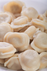 Fototapeta na wymiar Appetizing dumplings, vareniki, ravioli, momo close-up. Traditional dish of Russia, Italy, Asia. Boiled dough with filling. Dumplings with meat, fish, vegetables. A hearty breakfast, lunch, dinner.