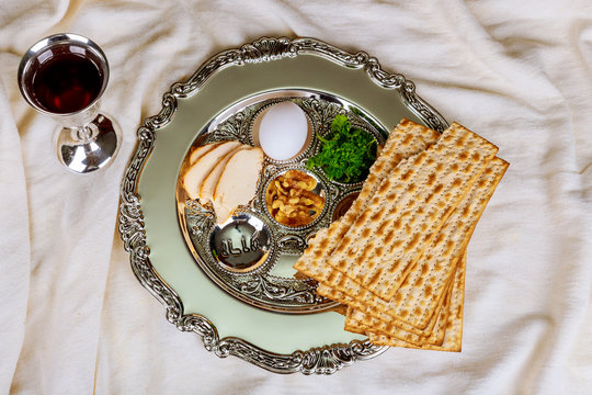 Passover background with wine bottle, matzoh, egg and seder plate