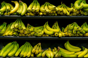 Bananas lie on a black shelf in the supermarket