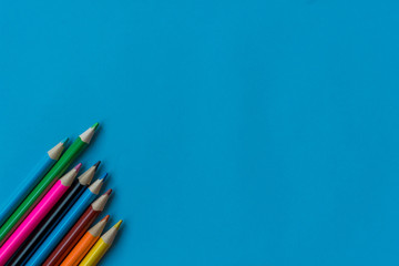 Color pencils on blue background, copy space