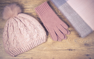 Fototapeta na wymiar Warm winter knitted clothes on a wooden background.