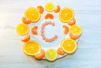 Vitamin C concept. Orange and tangerine and lemon slices and citrus fruits shape pills on a white...