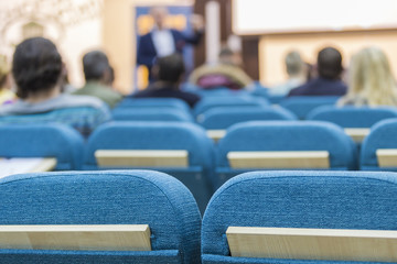 Business Meetings Concepts. Male Presenter Holding a Conference In Front of a Group of Listeneres.
