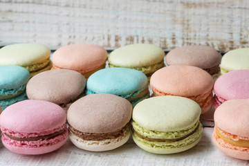 multicolored macaroni cakes on wooden background