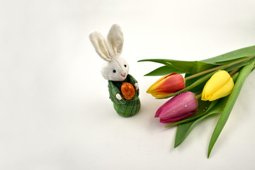 Colorful tulips with Easter bunny stock images. Easter decoration on a white background. Spring decoration images. Bouquet of colorful tulips. Easter Bunny with tulips