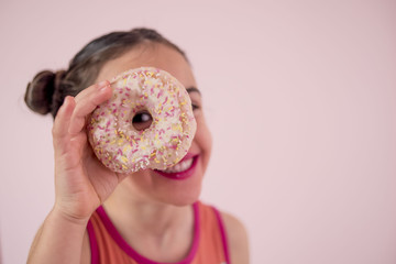 Little girl looking between donuts
