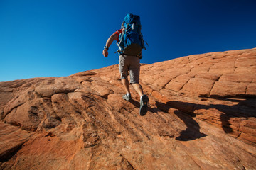 Hiker on a trail in volcanic Snow canyon State Park in Utah, USA