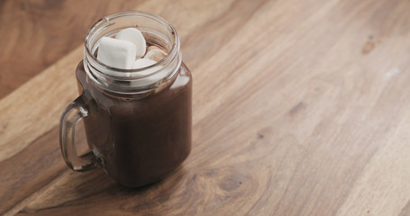 cocoa drink in glass jar with handle on wood table