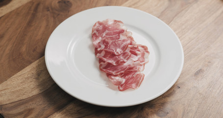 coppa on white plate on wood table
