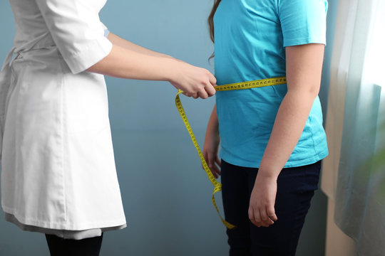 Doctor measuring overweight girl in clinic