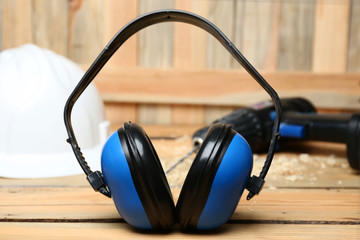 Headphones and hard hat on table. Hearing protection