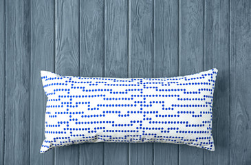 Stylish soft pillow on wooden background