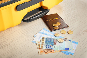 Passport, money and arrival cards on table near suitcase. Immigration reform
