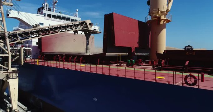 Drone flyover of unidentified bulk grain ship loading grain at southern Australian port. 