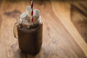 cocoa drink in glass jar with handle on wood table