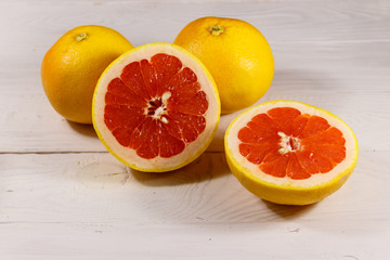 Ripe fresh grapefruits on white wooden table