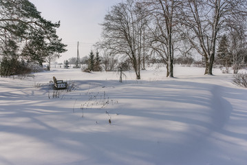 In the winter landscape, in the garden near the house there is a lot of snow. There is a lot of snow in the house yard after a snowstorm. Large snow drifts in the yard.