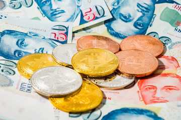 Singapore Dollar banknotes and Bitcoin Cryptocurrency coins on White background
