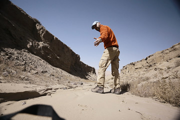 lonely man travels along deserted canyon,  desert,  lifeless terrain,  landscape of highlands