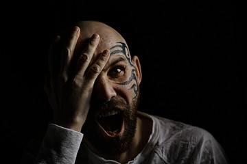 tattoo on the face,  man with a tattoo,  brutal bearded guy, studio portrait of a man