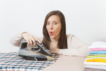 Close up beautiful housewife in light clothes ironing husband checkered shirt, clothing on ironing...