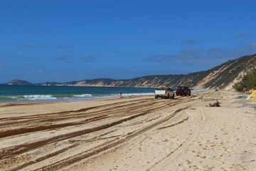 Lonely hiker along the well-known 4WD track at the colored sands cliffs in Rainbow Beach, Queensland, Australia
