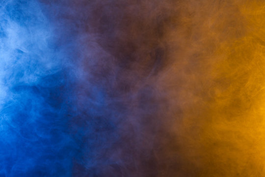 Blue And Yellow Smoke Texture On A Black Background. Texture And Abstract Art