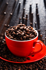 Composition with red cup of coffee and beans