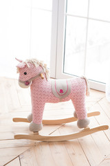 Unicorn toy horse near the window on the wooden floor