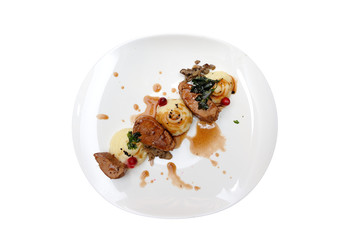 A nice dish with meat, mashed potatoes, sauce and greens. Isolated