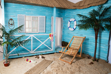 Deck chair sand beach like blue house wooden bungalow with palms 