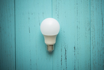 LED light bulb on shabby wood
