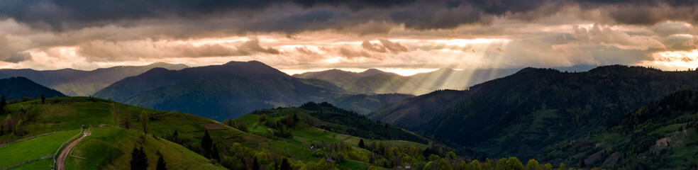 panorama of mountainous countryside at sunset. country road through rolling hills in to the...