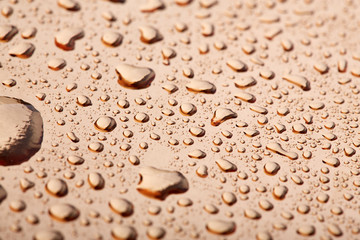 Colored water droplets on a gold background. Abstract liquid sprays
