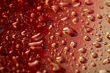 Colored water droplets on a gold background. Abstract liquid sprays