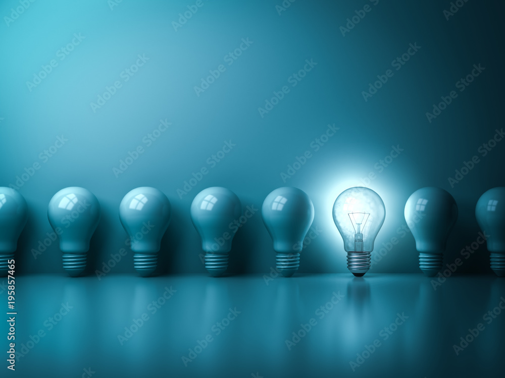 Leinwandbilder one glowing idea light bulb standing out from unlit incandescent bulbs on dark green pastel color ba