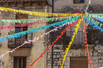 Ancient facade houses and decorated street for festa major, celebration, in medieval village of Besalu, Garrotxa, province Girona, Catalonia.Spain.