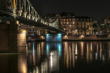 The iron bridge on Main river in Frankfurt during the night. Concept: architecture or travel and vacation