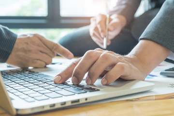 Business concepts,Two men use laptop analyze job,Pen in men's hand.