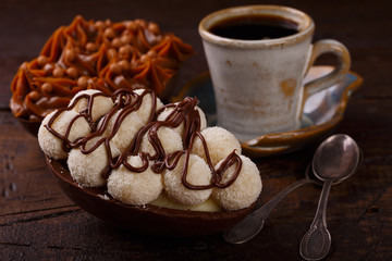 Chocolate egg ith filling for Easter on wooden background